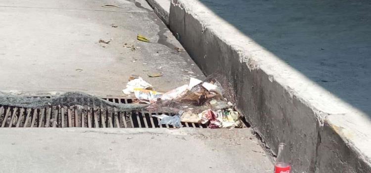 Personas tiran basura a drenaje Personas tiran basura a drenaje